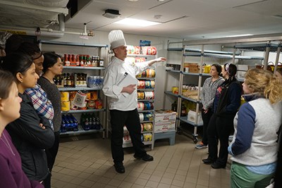 Executive sous chef Mike Petit shows students the food pantry 