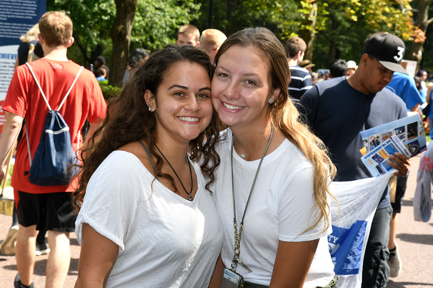 Two female students outside at engagement fair (close up) smiling