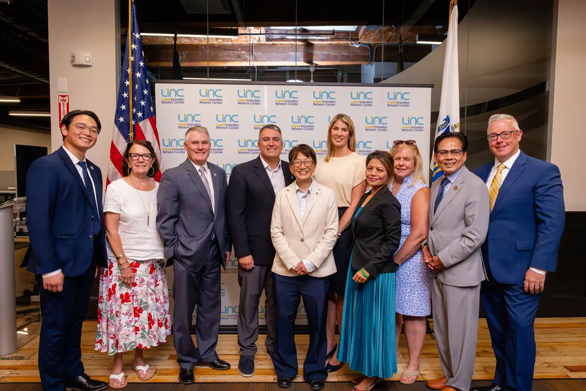 Ten officials pose in front of a LINC backdrop.