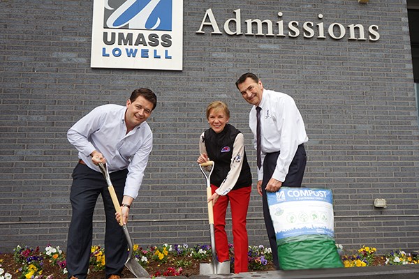 University staff members pose with a bag of the new compost
