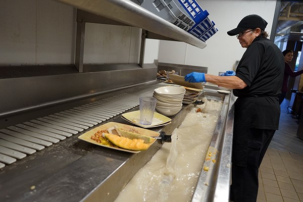 A dining hall employee removes food waste to be composted