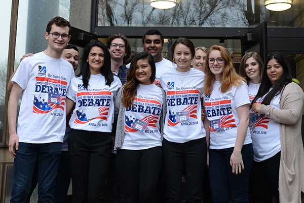 Students pose for a photo outside of Durgin Hall on debate day