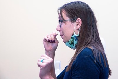 a student swabs her nose to test for COVID-19