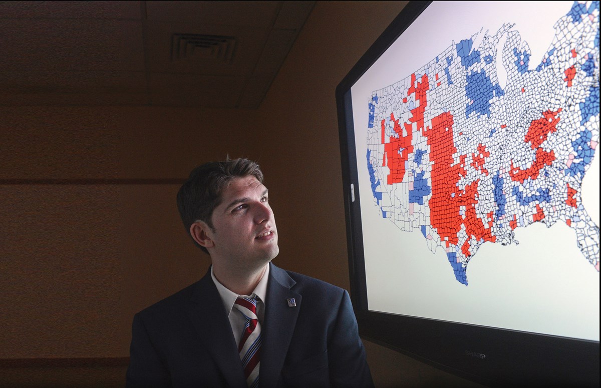 Prof. Joshua Dyck looks at polling map on large screen