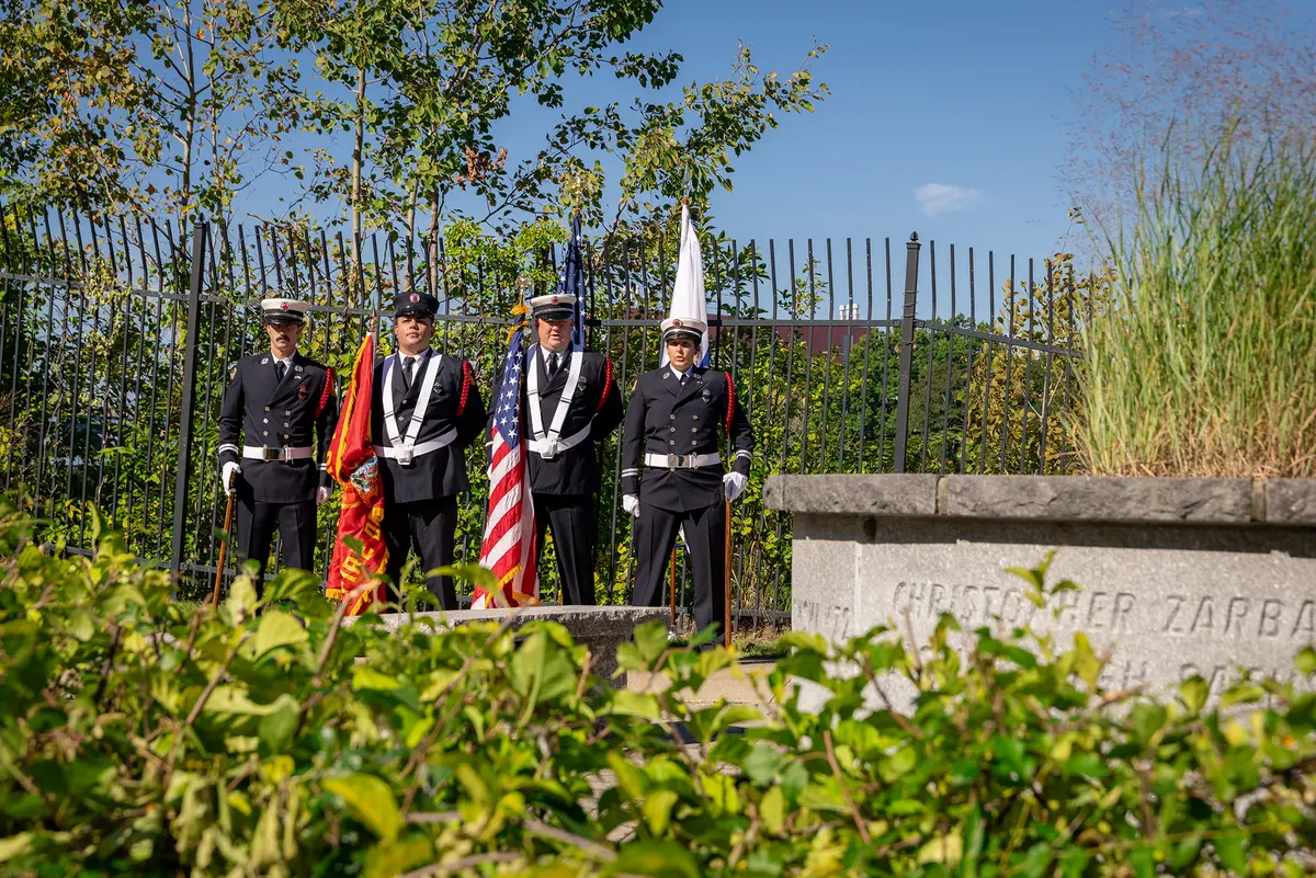 The Lowell Fire Guard stands at attention near "Unity," UMass Lowell's Sept. 11 memorial.