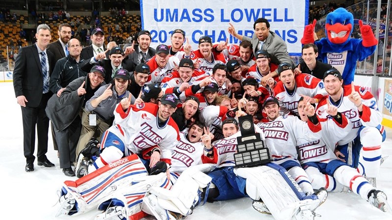 The UMass Lowell hockey team and coaches celebrate on the ice with Rowdy the River Hawk as Hockey East champs in 2013
