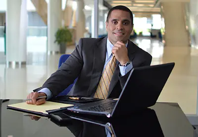 Photo shows UMass Lowell online education graduate Kelvin Juarbe in his office