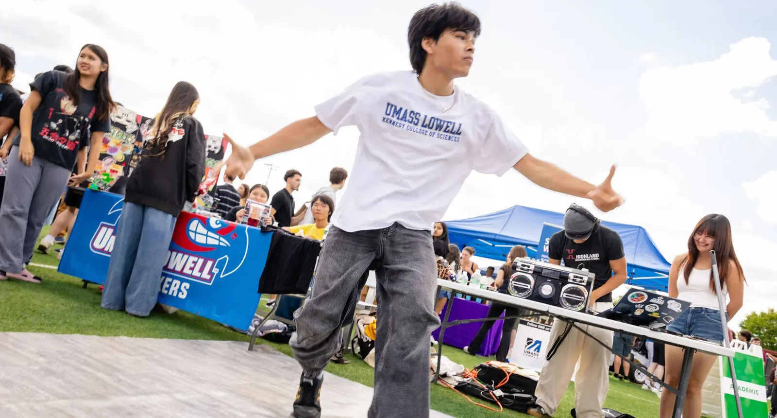Student wearing UMass Lowell Kennedy College of Sciences T-shirt dances at Engagement Fair
