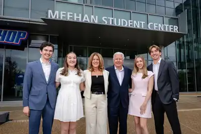 UMass President Marty Meehan stands in front of the newly renamed Meehan Student Center with his wife Jennifer and their four children