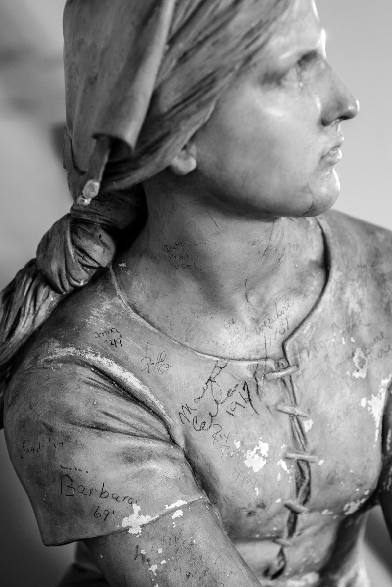 Plaster sculpture of Joan of Arc adorned with student signatures