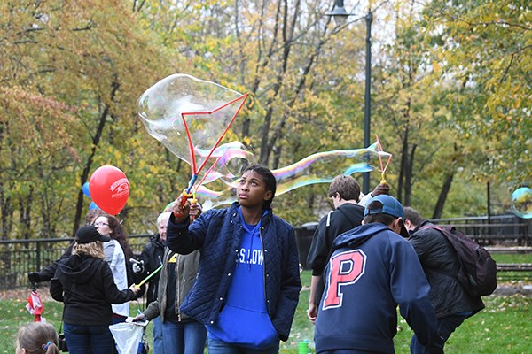People creating giant bubbles at the Inventor Mentor booth at UML Homecoming