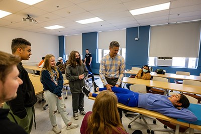 Physical Therapy and Kinesiology Clinical Associate Prof. Edgar Torres helps with a biology activity led by UTeach student Mareena Soliman for students from Methuen High School