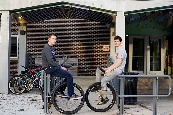 Evan Jones and Andrew Terrill with their unicycles outside of Leitch Hall