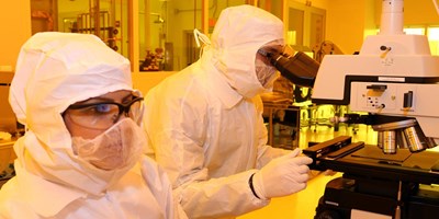 Two people working in the clean room at the Saab ETIC Building.