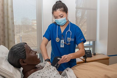 UML Nursing major Nancy Pin practices taking vital signs in the UMass Lowell simulation lab
