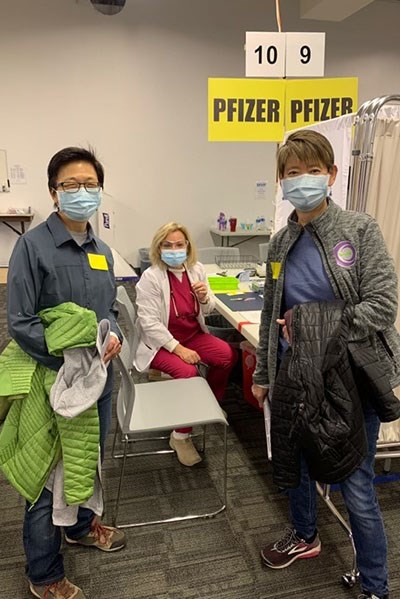 Assoc. Vice Chancellor Julie Chen and her wife, Susu Wong, get vaccinated by Nursing Prof. Lisa Abdallah, who volunteers at Lowell General Hospital's vaccination clinic