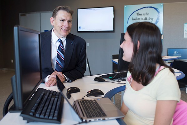 Provost Mike Vayda speaks with a student employee at the Solution Center