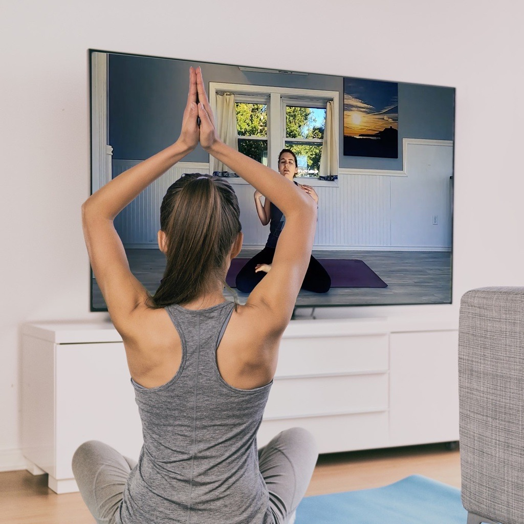 Picture of student doing yoga in front of their television