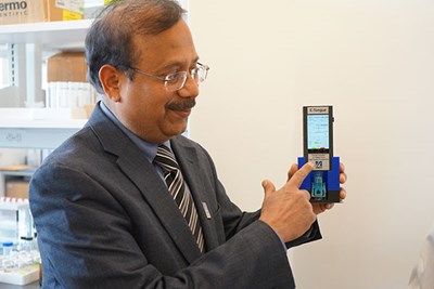 Professor Pardeep Kurup shows off the Electronic Tongue, a handheld device.