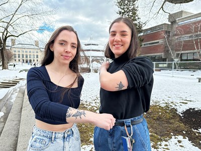 Collette, left, and Diana Whitcomb show off their matching grasshopper tattoos on the snowy South Campus quad