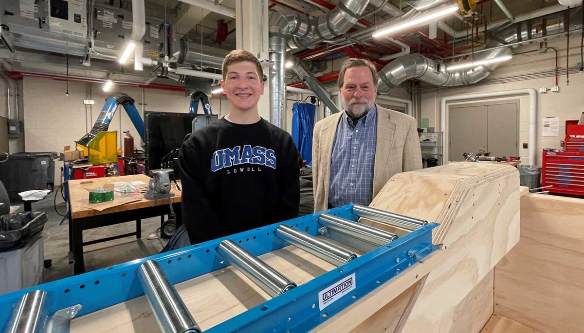 UMass Lowell Prof. Bryan Buchholz and student William Zouzas stand next to Zouzas' conveyor platform system to help lobstermen pull heavy traps out of the water. 