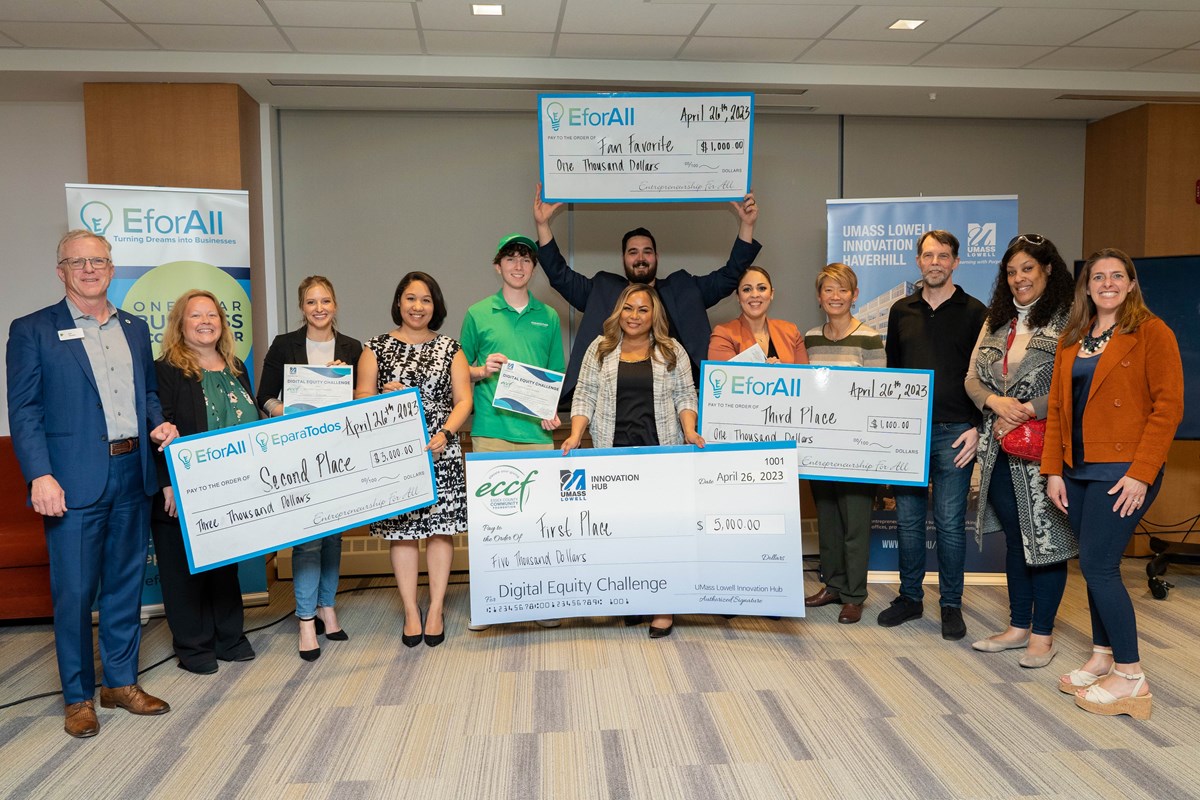 Group of Digital Equity Challenge winners hold up giant checks.