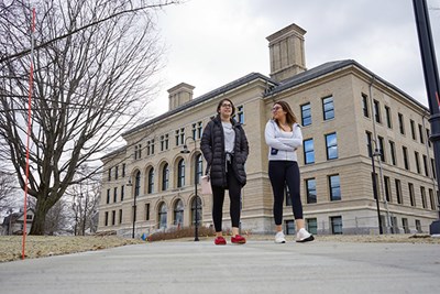 Two students walk in front of the renovated Coburn Hall