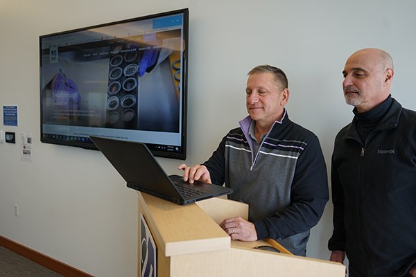 Information Technology staff members try the wireless presentation technology in a University Crossing conference room