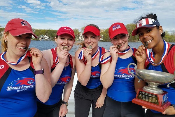 The women's varsity four rowers celebrate with their gold medals
