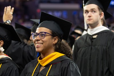 Student in cap and gown smiles