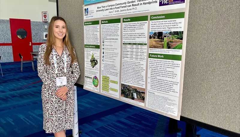 Alana standing next to poster