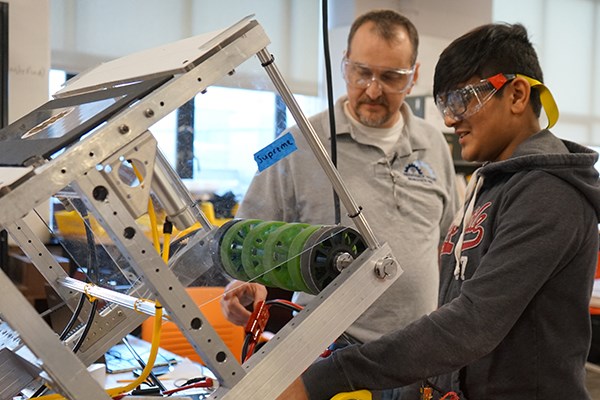 Mike Johnston and FIRST Robotics team co-captain Shivam Desai test a robot