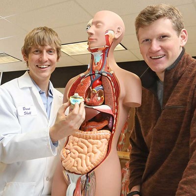 Student and professor look at an anatomy dummy