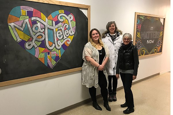 Chalk artist Anna Dugan '18, Assoc. Prof. Marie Frank and Art & Design Chair Jehanne-Marie Gavarini between the designs Dugan added to the historic chalk boards found during the renovation of Coburn Hall. 