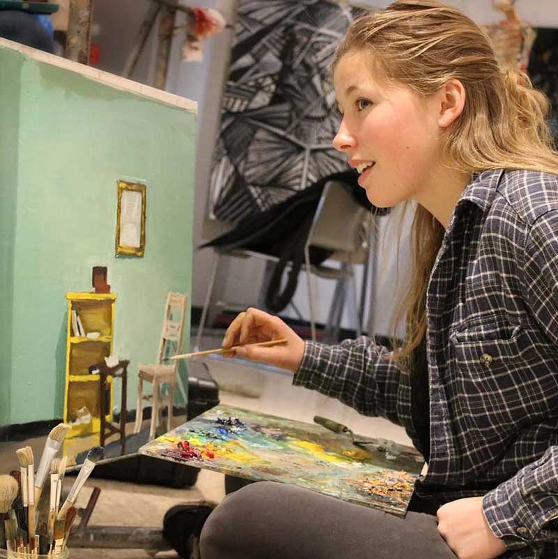 Art student painting in a UMass Lowell studio