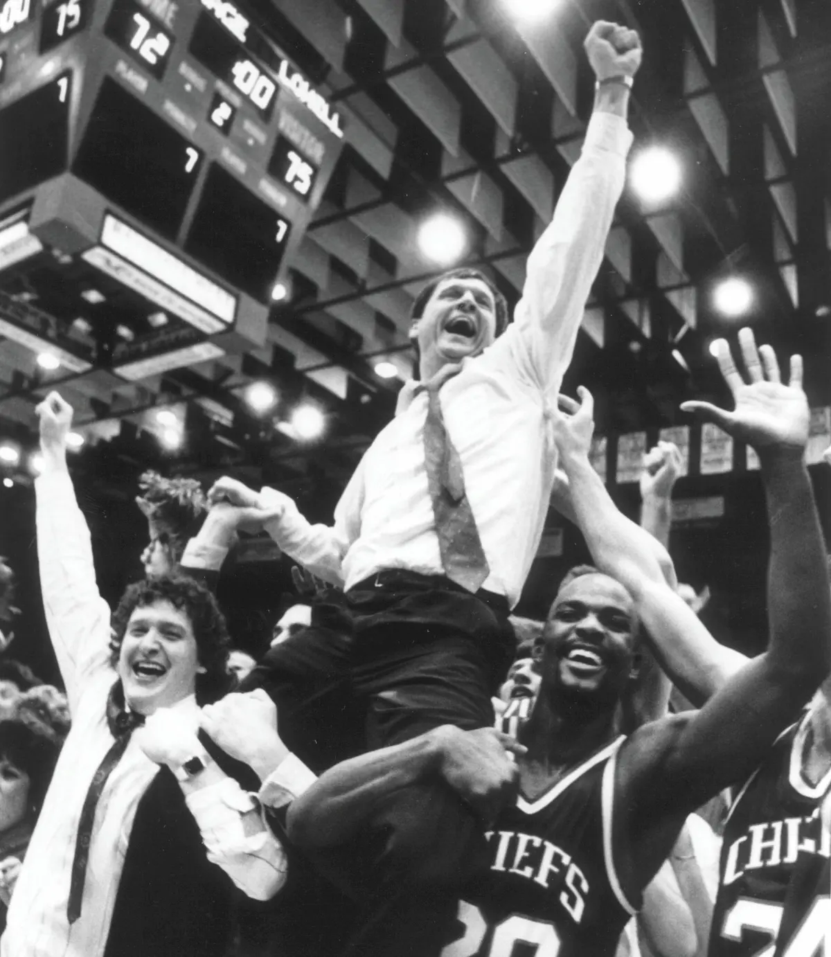 Basketball Coach Dan Doucette raises his fist in triumph