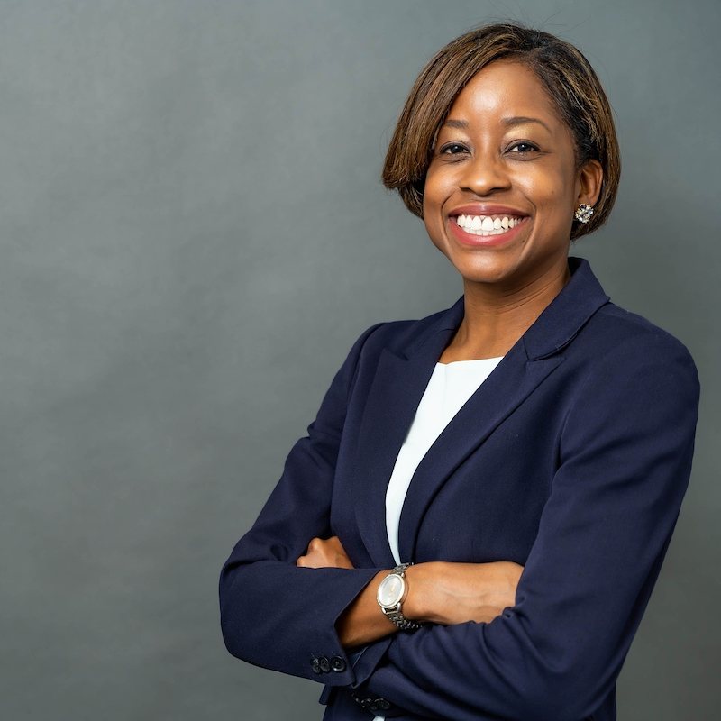 African American businesswoman smiling wearing business suit.
