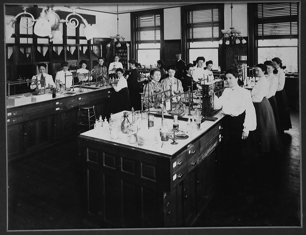 Female students working in chemistry lab pose for a photo in 1905