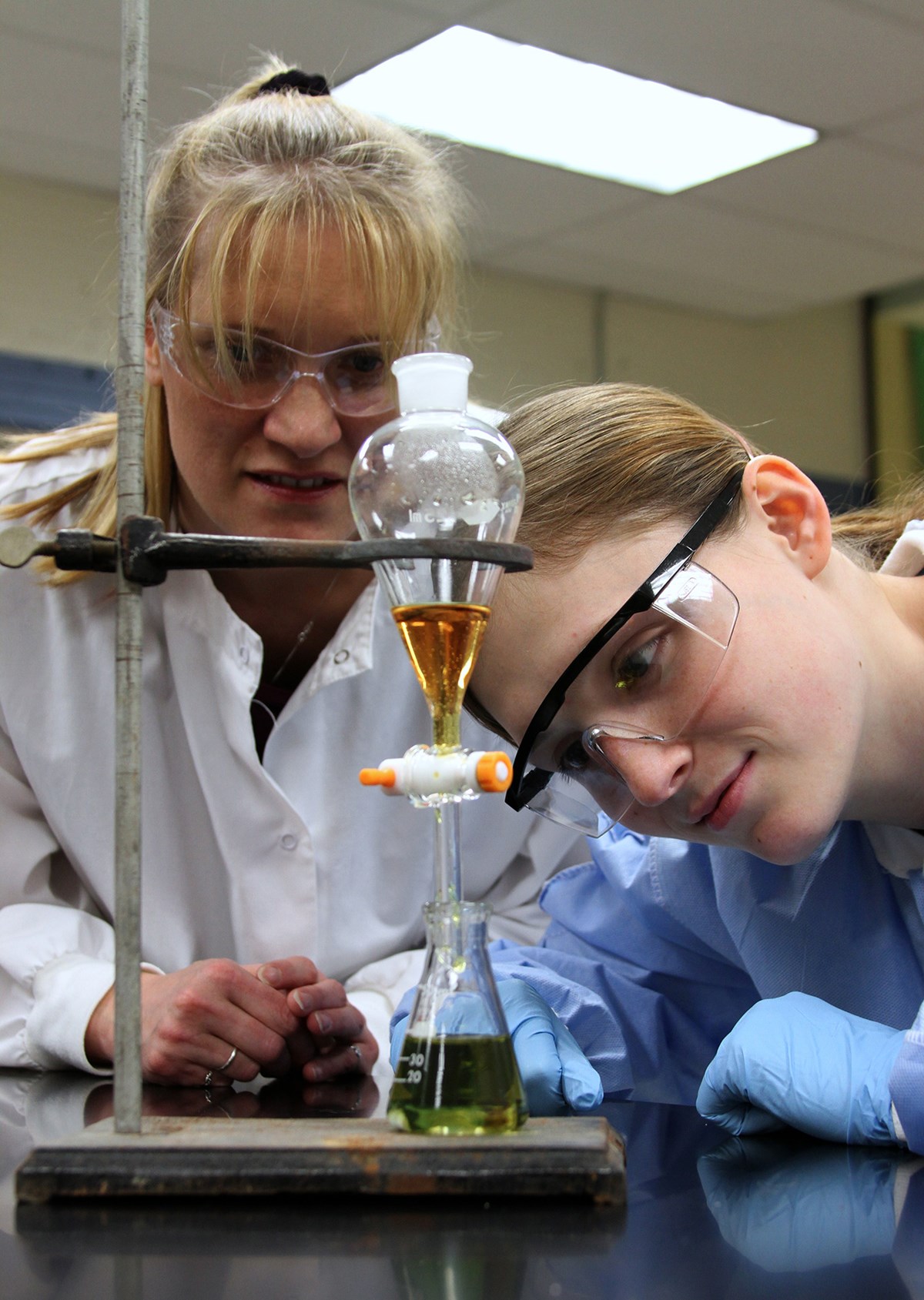chemistry-female-faculty-female-student-heating-liquid