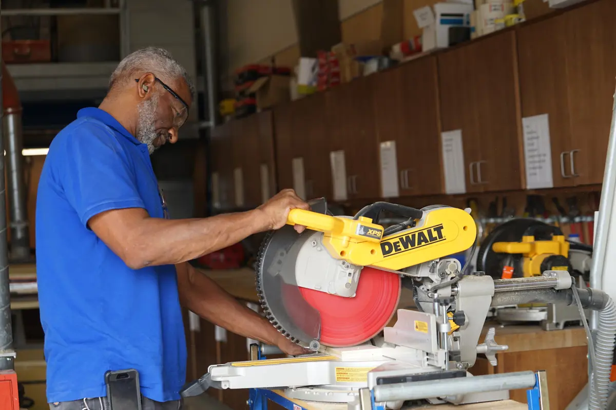 Worker wearing safety goggles operating a circular saw