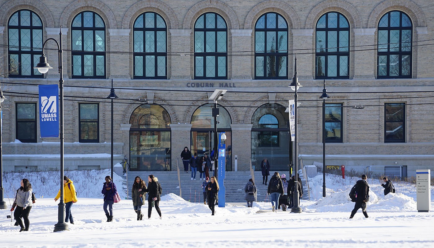 Students walk in front of Coburn Hall on UMass Lowell's South Campus amid snow