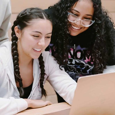 Two students look at a laptop computer screen
