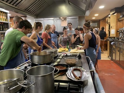 Study abroad students cook in a kitchen together at a gastronomical society 