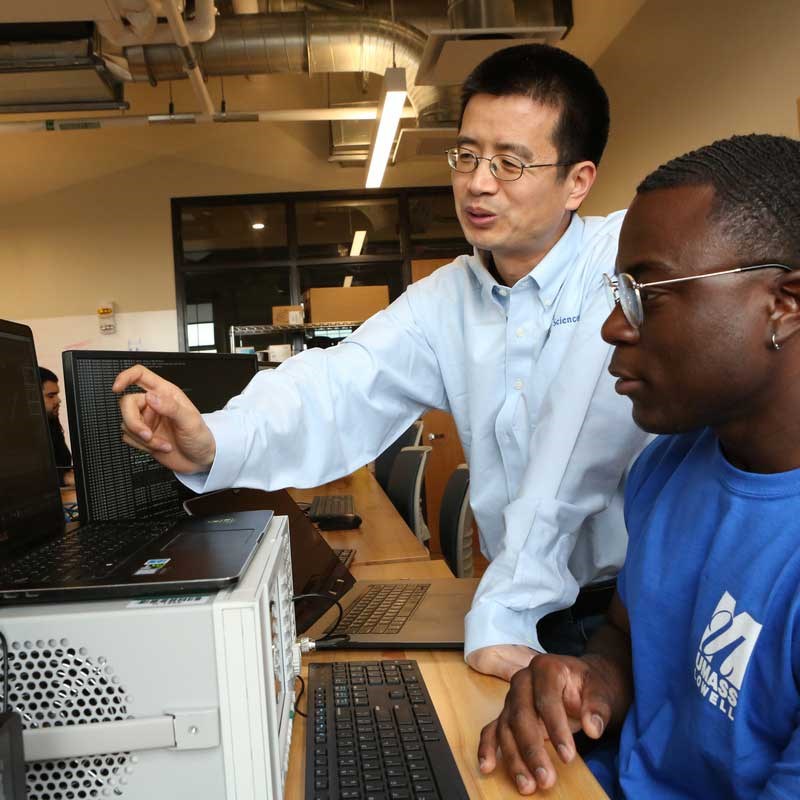 Professor and student work on a computer at the UMass Lowell Cyber Range