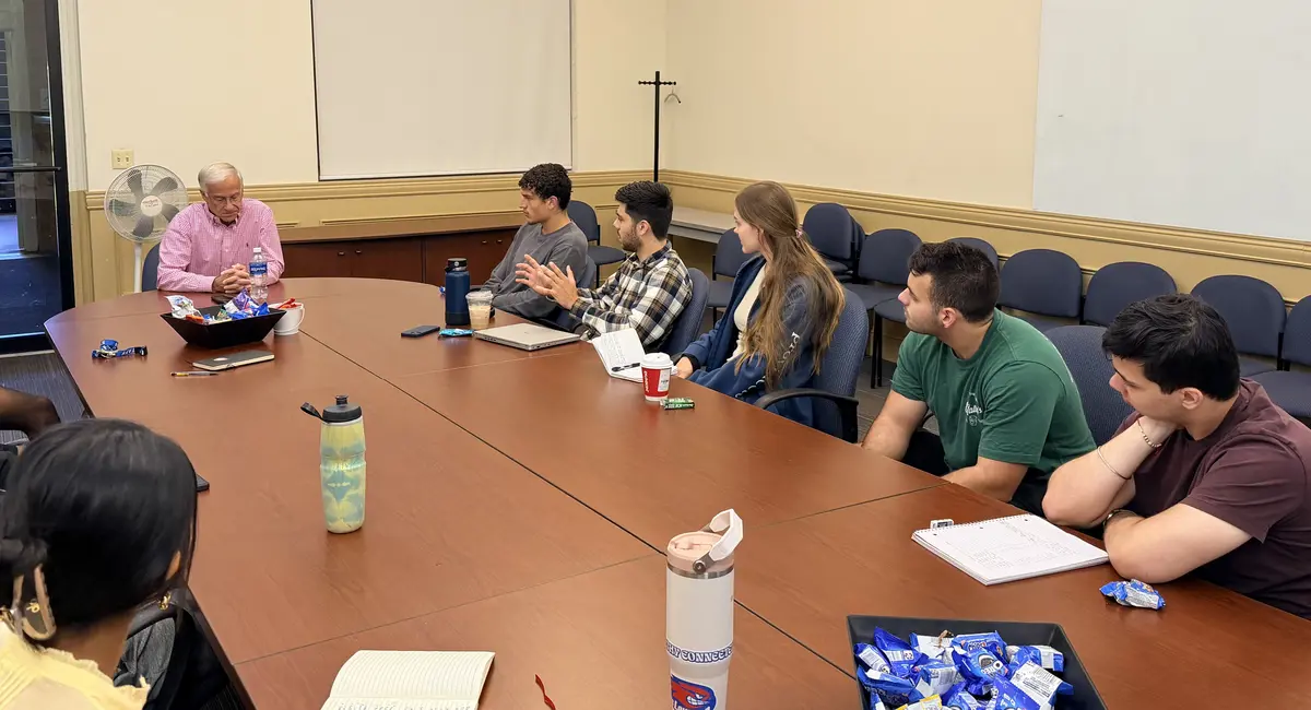 David Laurello talking to Shah Academy students around a table.