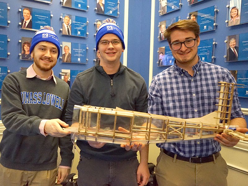 Brett Wadman, Ben Francoeur and Sean Roche hold the partially constructed plane 