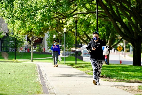 Two students walk on East Campus with their takeout meals