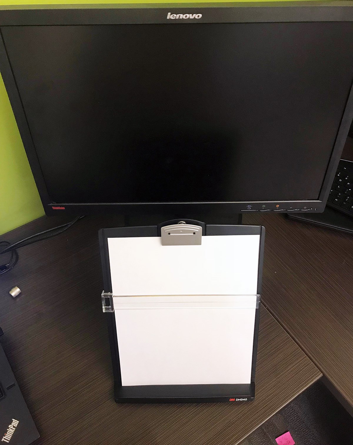 A document holder sits in front of a monitor so a user can easily transfer data from the paper to the computer. 