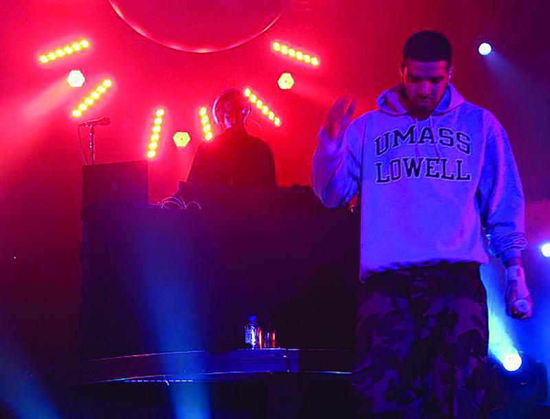 Drake onstage at the Tsongas Center wearing a UMass Lowell hoodie