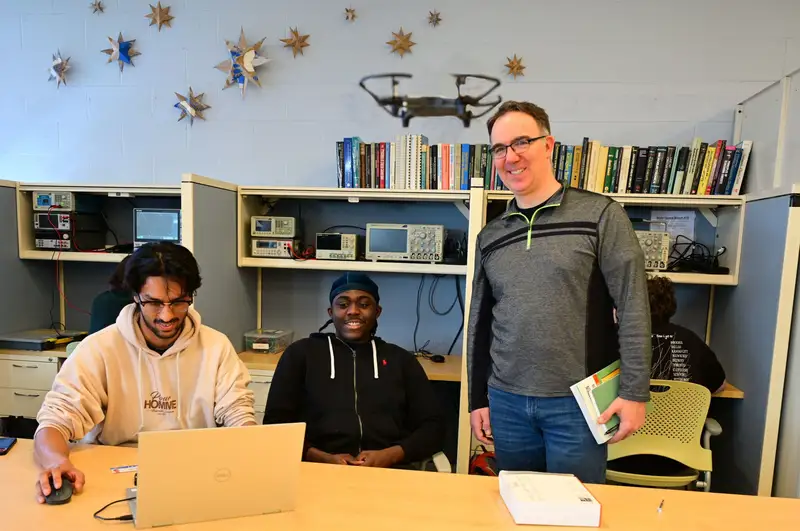 A capstone project team and faculty mentor flying a drone